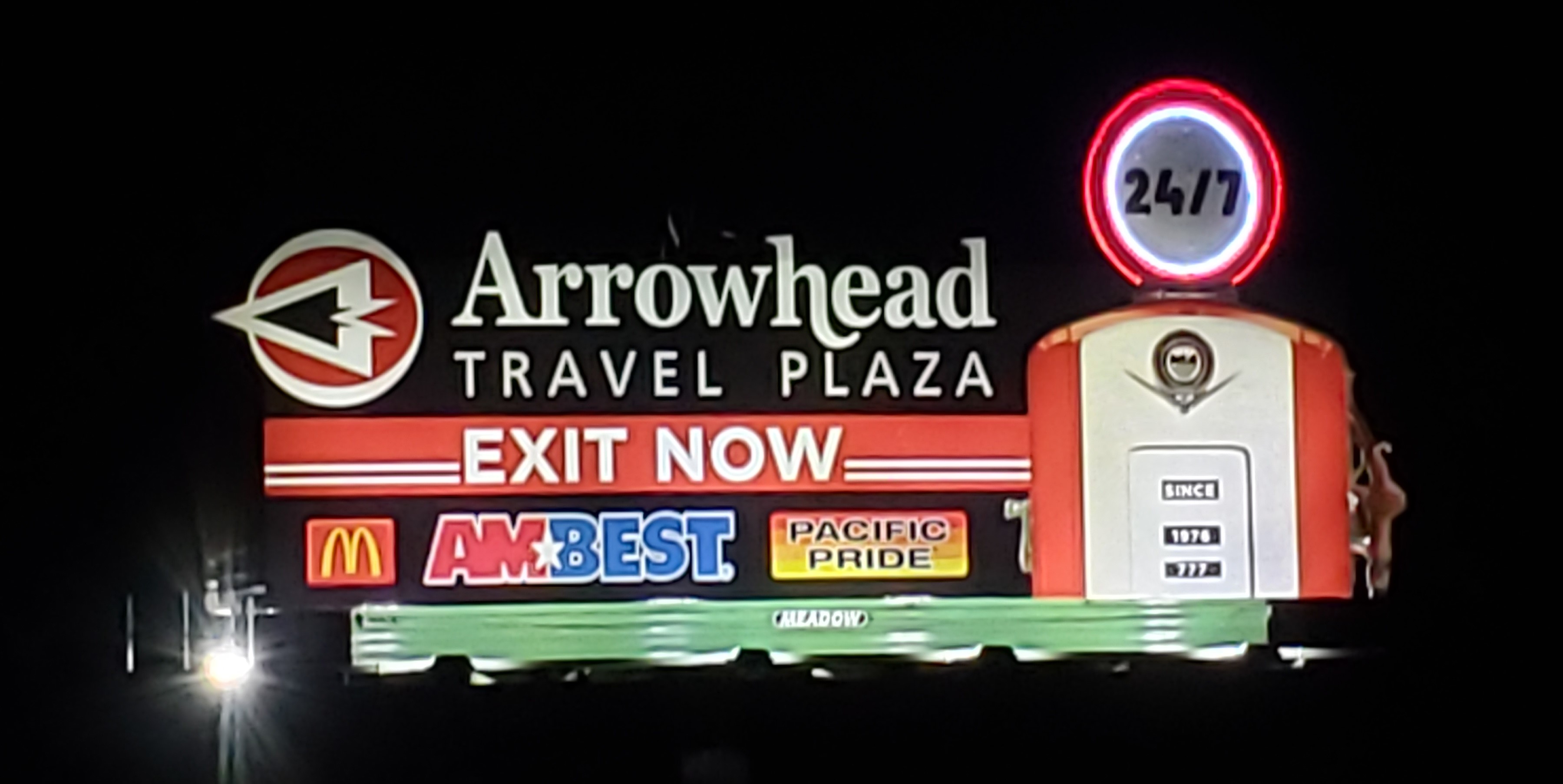 Arrowhead Travel Plaza illuminated display on billboard at night