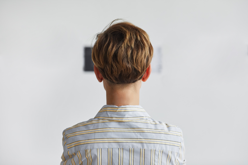 The back of girl's head looking at a distance wall