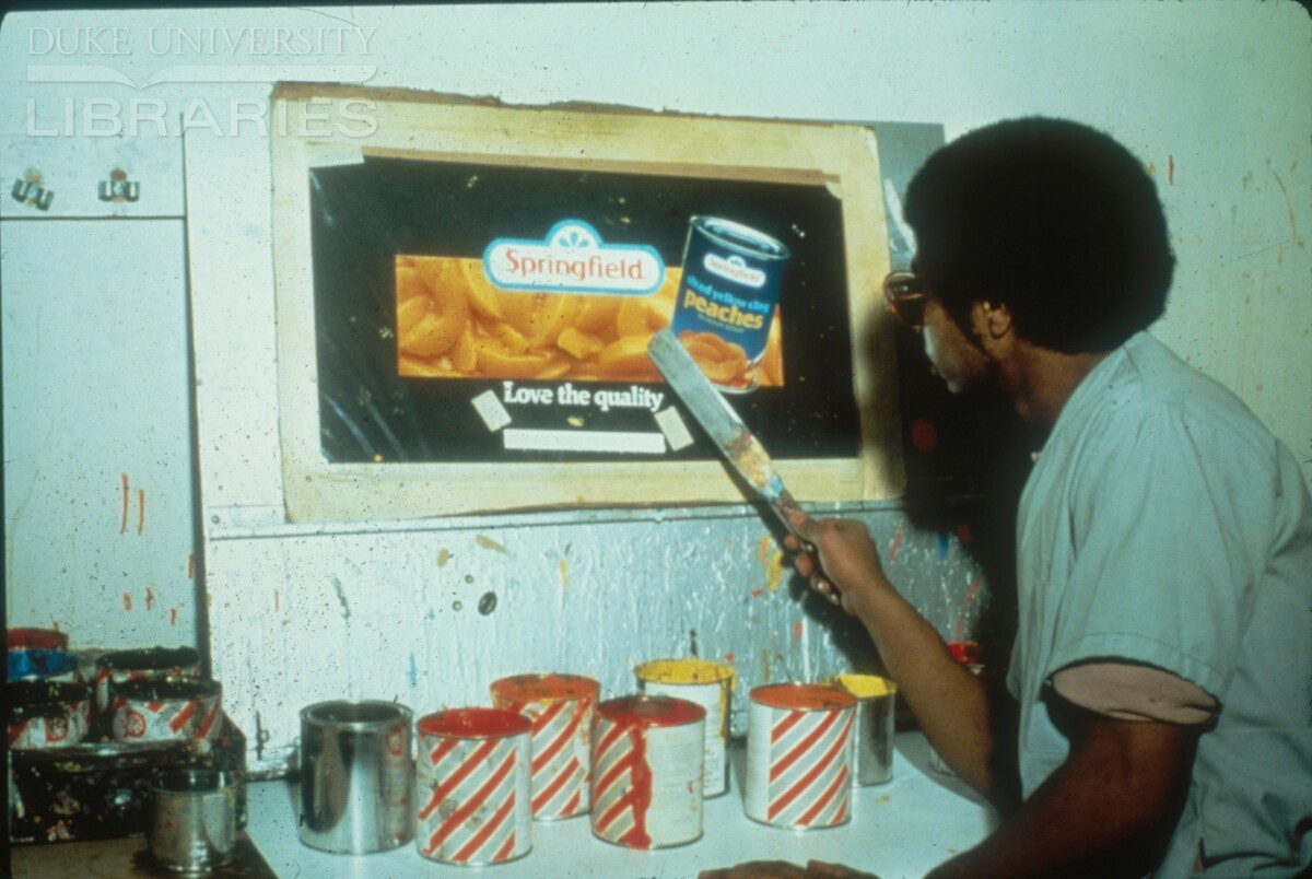 A painter is selecting paint colors for billboard based on billboard design on wall 1970s