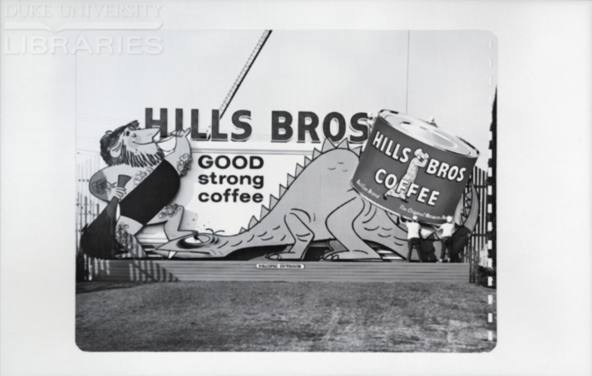 An installation crew places secures a final large coffee can cutout in front of previously installed dinosaur cutouts.