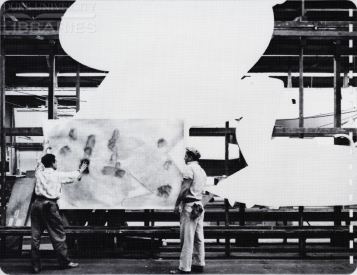 Two men pouce a painting pattern onto a cutout assembly.