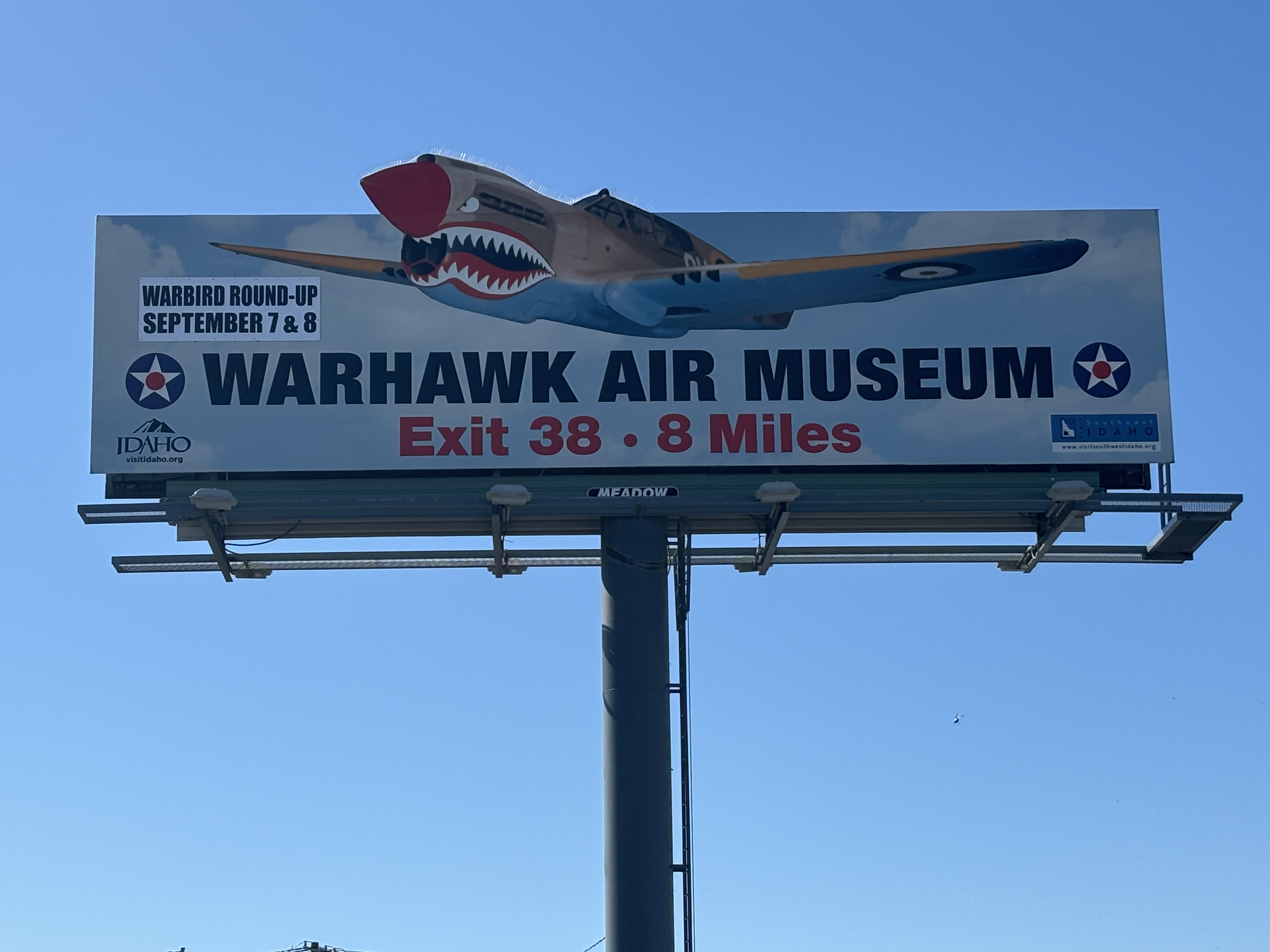 Billboard advertisement for Warhawk Air Museum with airplane