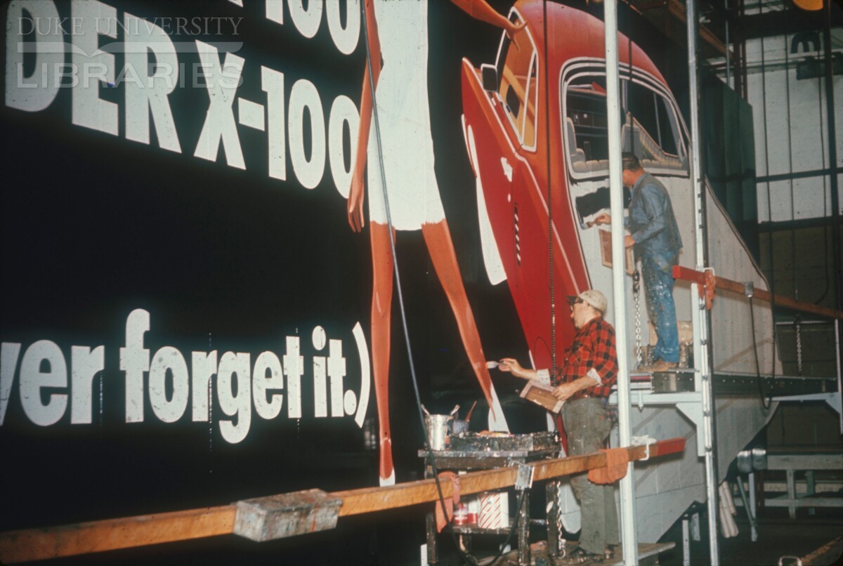 Artists painting a billboard ad